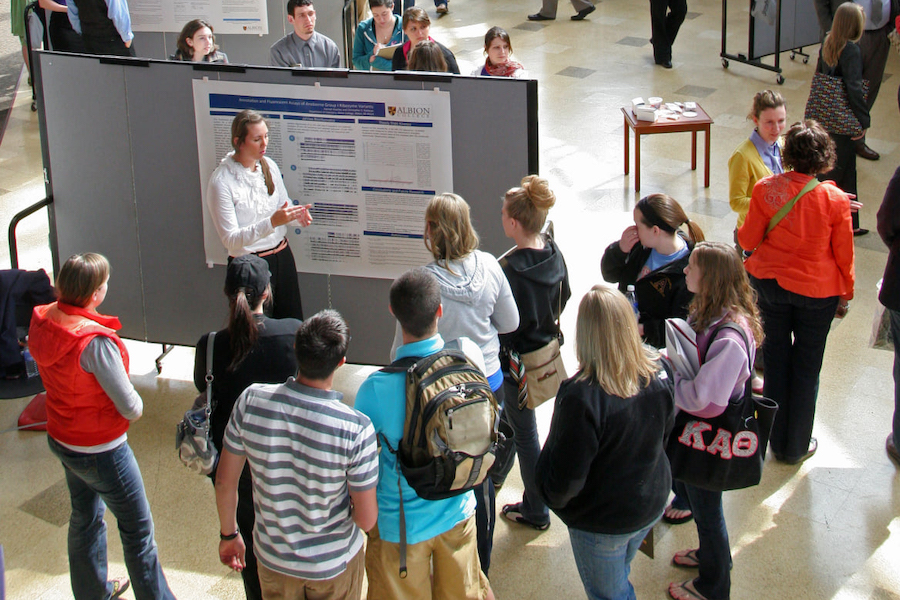 Students listening to a poster presentation in the Science Atrium.