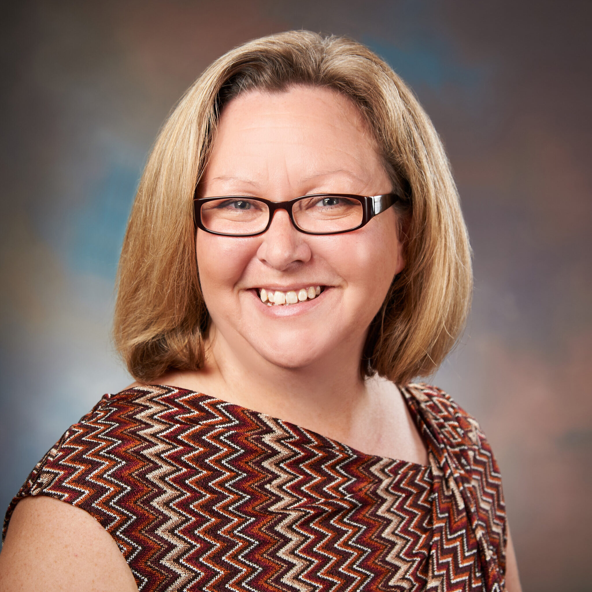 A professional headshot of Elisa Reynolds.