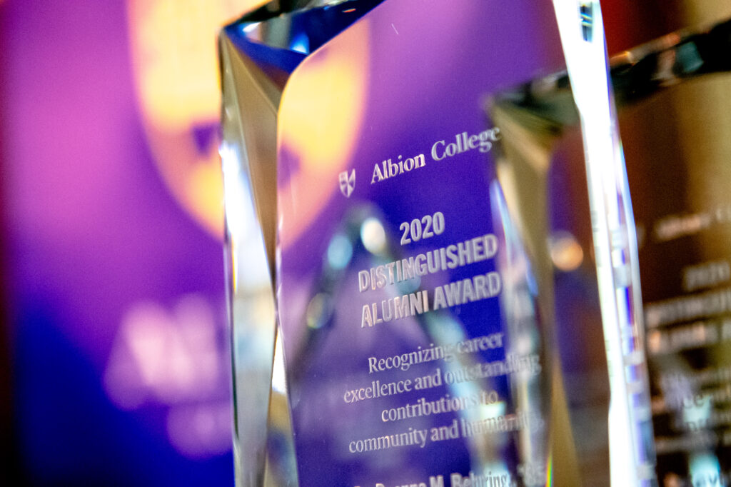 Crystal award in front of a purple background